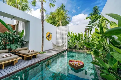 a swimming pool in a villa with palm trees at Casa Ipanema, Luxury 2 Bedrooms Villa with Cinema in Private Quiet Area in Canggu