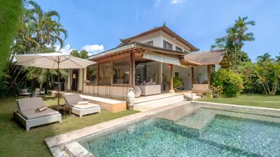 a villa with a swimming pool and a house at Villa Mogi by Villa Finder in Seminyak