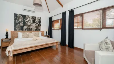 a bedroom with a bed and a couch at Villa Mogi by Villa Finder in Seminyak