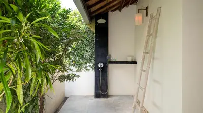a hallway with plants and a door with a ladder at Villa Mogi by Villa Finder in Seminyak