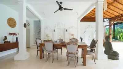 a dining room with a table and chairs at Villa Mogi by Villa Finder in Seminyak