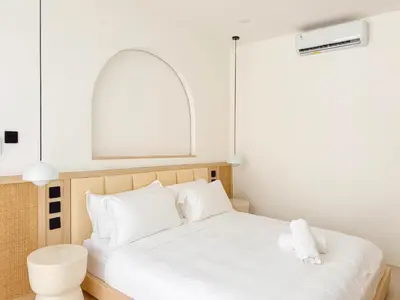 a bedroom with a white bed with a mirror above it at Anjou - Twin Villa in Berawa Canggu in Canggu