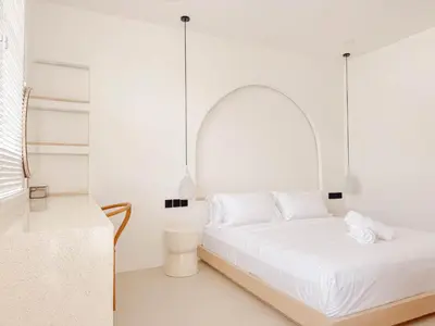 a white room with a bed and a table at Anjou - Twin Villa in Berawa Canggu in Canggu