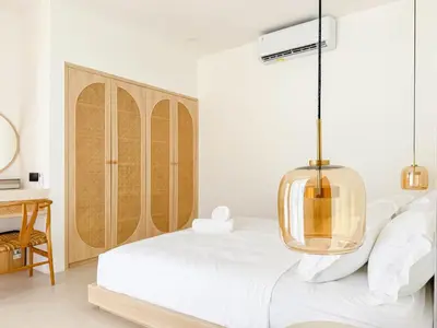a bedroom with a bed with a glass pendant at Anjou - Twin Villa in Berawa Canggu in Canggu