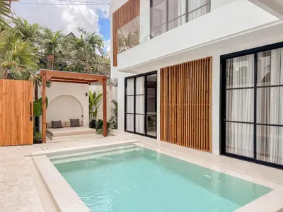 a swimming pool in the backyard of a house at Burgundy - Twin Villa in Berawa Canggu in Canggu