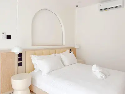 a bedroom with a bed with white pillows at Burgundy - Twin Villa in Berawa Canggu in Canggu