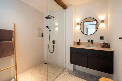a bathroom with a sink and a glass shower at Stylish 4 bedroom Villa in Prime Location in Canggu