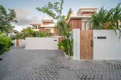 a house with white doors and some plants at Stylish 4 bedroom Villa in Prime Location in Canggu