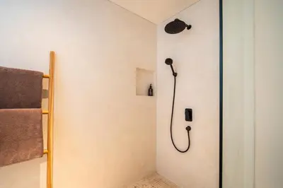 a shower in a bathroom with a shower head at Stylish 4 bedroom Villa in Prime Location in Canggu