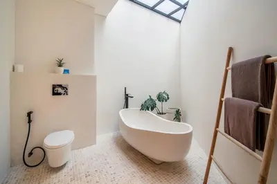 a bathroom with a white tub and a toilet at Stylish 4 bedroom Villa in Prime Location in Canggu