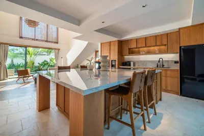 a kitchen with a large island with bar chairs at Stylish 2 bedroom Villa in Prime Location in Canggu