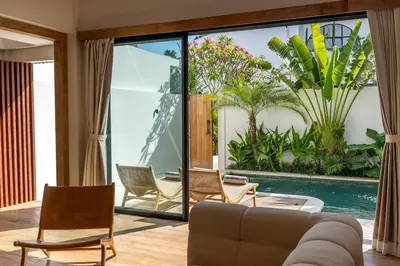a living room with a couch and chairs and a pool at Stylish 2 bedroom Villa in Prime Location in Canggu