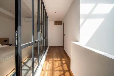 a hallway with glass and wood floors and a bed at Stylish 2 bedroom Villa in Prime Location in Canggu