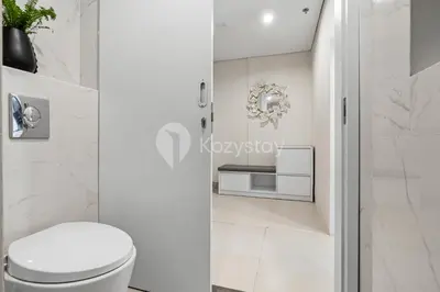 a white bathroom with a toilet and a sink at Alva by Kozystay - Nusa Dua in Nusa Dua