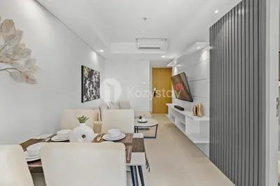 a living room with white furniture and a table and chairs at Alva by Kozystay - Nusa Dua in Nusa Dua