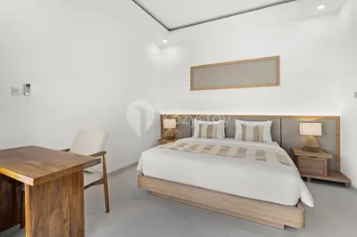 a bedroom with a bed and a desk and a mirror at Navaya Villa by Kozystay - Seminyak in Seminyak