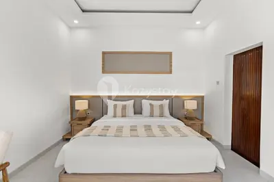 a bedroom with a large white bed and two night stands at Navaya Villa by Kozystay - Seminyak in Seminyak
