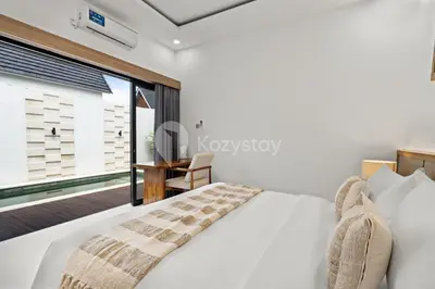a bedroom with a white bed and a window at Navaya Villa by Kozystay - Seminyak in Seminyak