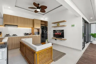 a living room with a ceiling fan and a kitchen at Navaya Villa by Kozystay - Seminyak in Seminyak