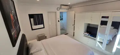 a white room with a bed and a tv at The Palmana Tropical Garden Jayakarta Residence 38 in Seminyak