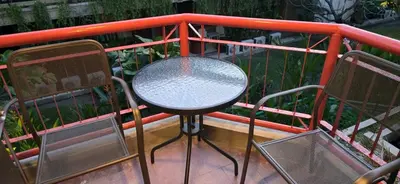 a table and two chairs on a balcony at The Palmana Tropical Garden Jayakarta Residence 38 in Seminyak