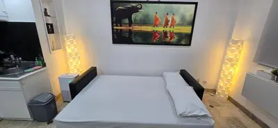 a room with a white couch and a painting on the wall at The Palmana Tropical Garden Jayakarta Residence 38 in Seminyak