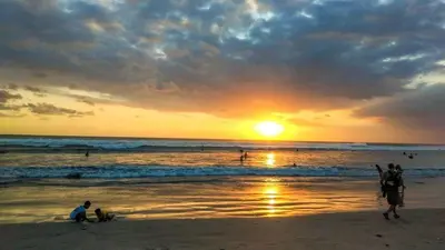 a group of people on the beach at sunset at W Hotel at Kuta Beach By Micky Studio -1 minutes to beach in Legian