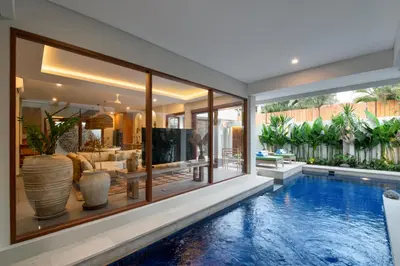 a house with a swimming pool and a living room at Levan Villa Seminyak in Seminyak