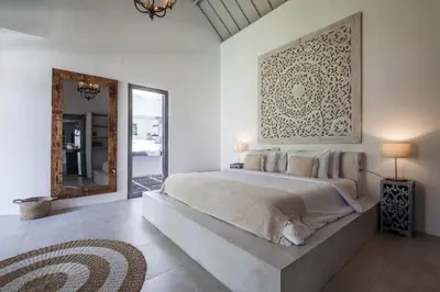 a bedroom with a large bed and a mirror at House of Winds Complex - Stylish 12BR Design Estate - 4 Villas near Canggu in Kerobokan