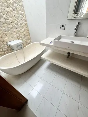 a white bathroom with a tub and a sink at Phil's Harmony Seminyak in Kerobokan