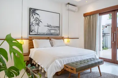 a bedroom with a bed with a bench in it at Villa Mai Mai Seminyak in Seminyak