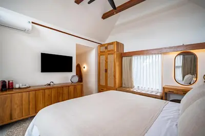 a bedroom with a white bed and a tv at Villa Mai Mai Seminyak in Seminyak