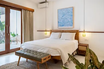 a bedroom with a bed with a bench in it at Villa Mai Mai Seminyak in Seminyak
