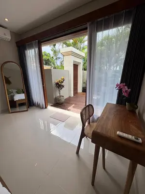 a dining room with a table and a large window at Villa Elysia in Canggu