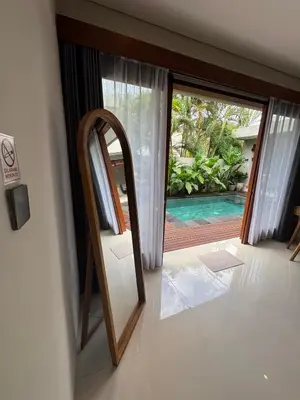 a room with a mirror and a door to a pool at Villa Elysia in Canggu