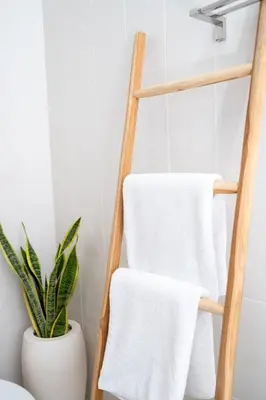 a towel rack with white towels in a bathroom at Villa Kunti in Seminyak