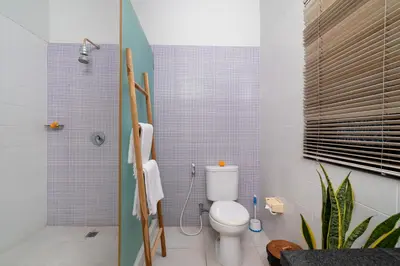a bathroom with a toilet and a shower at Villa Kunti in Seminyak