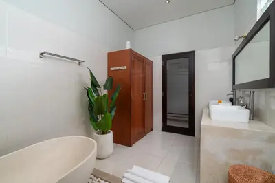 a bathroom with a tub and a sink and a toilet at Villa Kunti in Seminyak