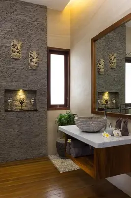 a bathroom with a large stone sink and a mirror at The Secret Villas in Seminyak