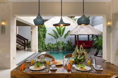 a dining room with a table and a pool at The Secret Villas in Seminyak