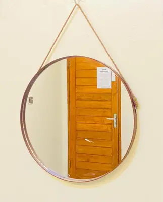 a mirror with a wooden door reflection in it at Room in Guest House near Kuta Beach Bali in Pesanggaran