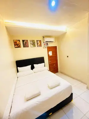 a bedroom with a large white bed with two pillows at Room in Guest House near Kuta Beach Bali in Pesanggaran