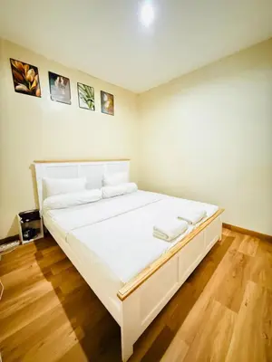 a large white bed in a room with wooden floors at Room in Guest House near Kuta Beach Bali in Pesanggaran