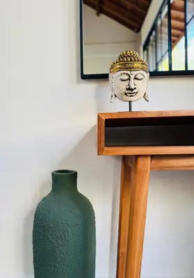 a green vase sitting on a shelf next to a wall at Villa Nelaya - Modern 3BR Retreat Private Pool Walk to the Beach in Seminyak