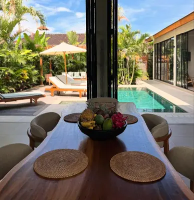 a wooden table with a bowl of fruit on it at Villa Nelaya - Modern 3BR Retreat Private Pool Walk to the Beach in Seminyak