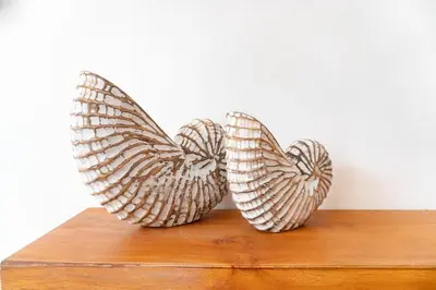 two metal sculptures of wings sitting on a wooden shelf at NEW! Queen Villa - 2BR Villa in Seminyak in Seminyak