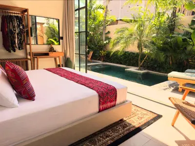 a bedroom with a bed and a swimming pool at Villa Allany - Modern 2BR Tropical Hideaway Private Pool in Seminyak