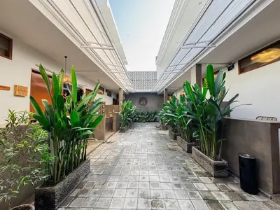 a hallway with potted plants in a building at SNUG Kuta in Kuta