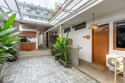 an indoor courtyard with plants and a kitchen at SNUG Kuta in Kuta