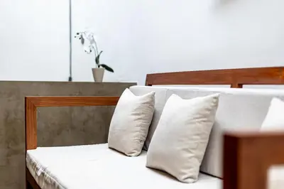 a bedroom with two beds with white pillows at SNUG Kuta in Kuta